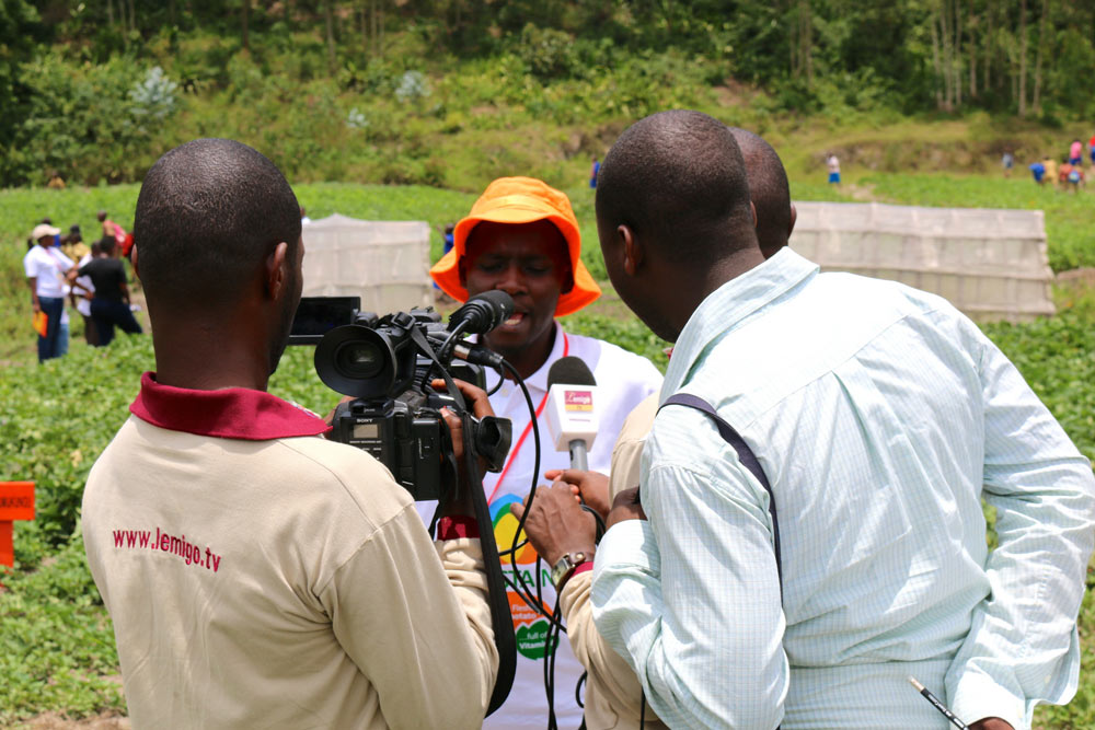 Jean Claude Nshimiyimana, Seed Systems Officer at CIP Rwanda discusses OFSP and SUSTAIN with the local media on a field trip to visit OFSP farmers, multipliers and processors